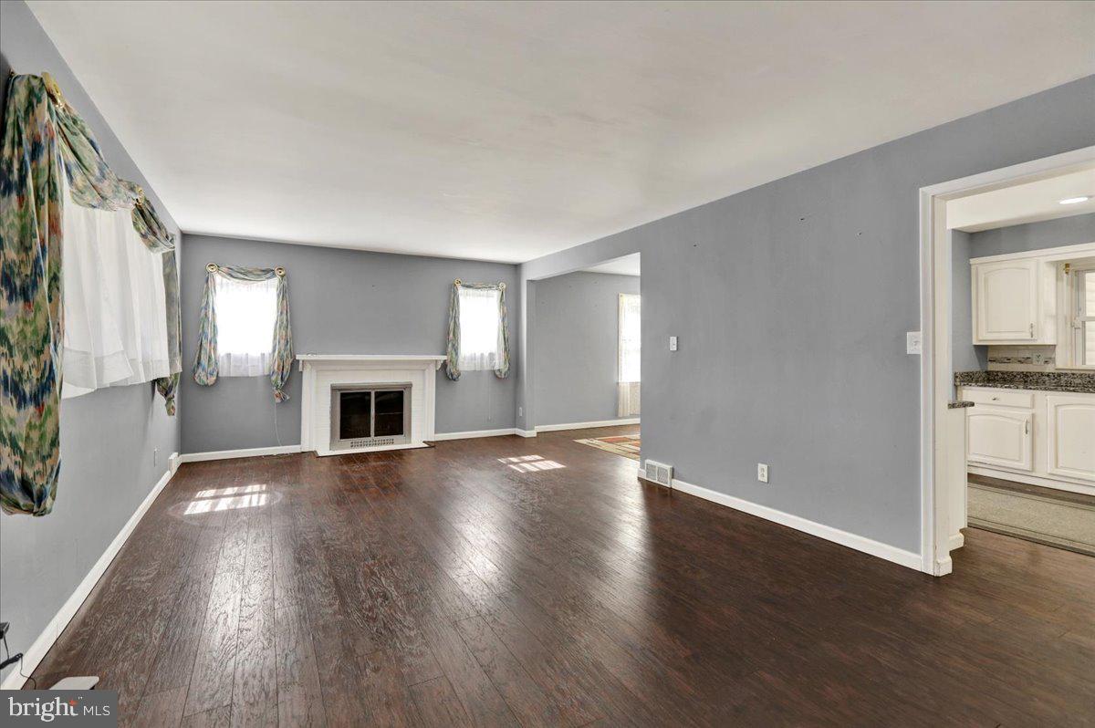 212 Mayer Street Reading, PA 19606 - Photo 4 of 37 an empty room with wooden floor fireplace and windows