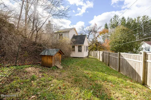 a view of a house with backyard and trees