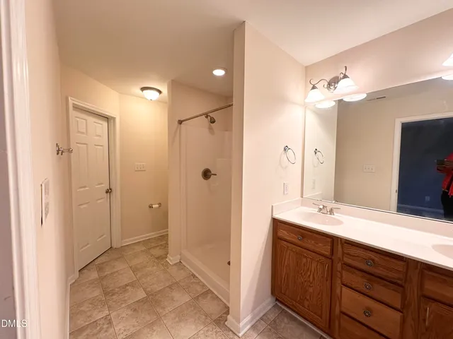 a bathroom with a double vanity sink mirror and shower
