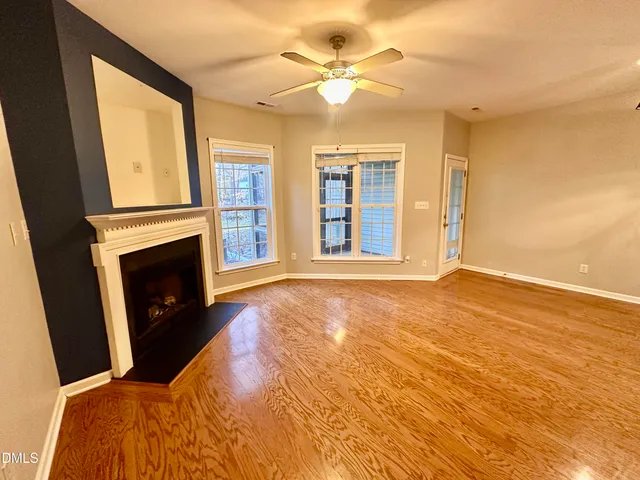 a view of an empty room with a fireplace and a window
