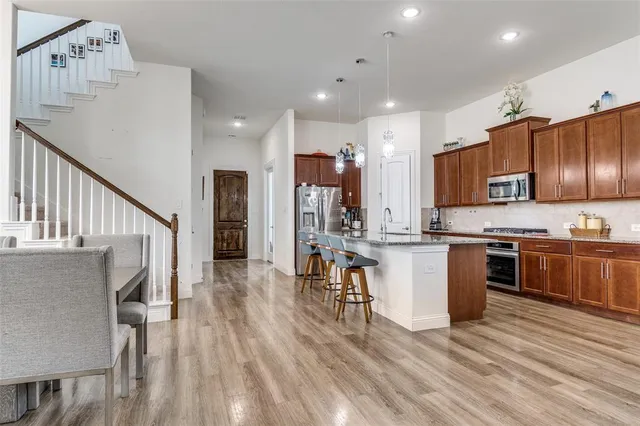 a kitchen with stainless steel appliances kitchen island granite countertop a sink and cabinets
