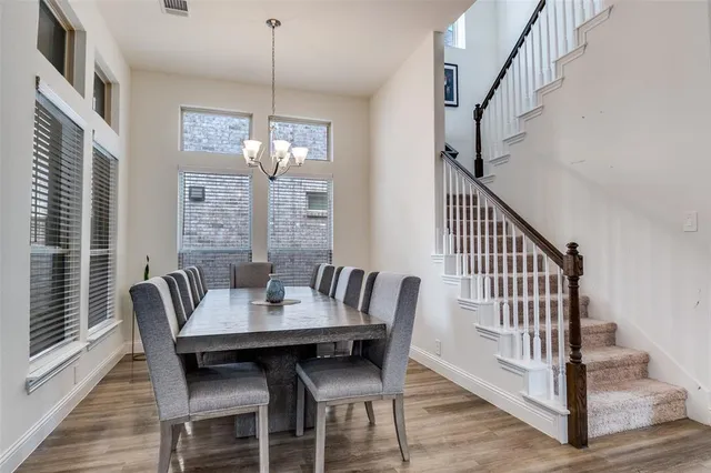 a kitchen with stainless steel appliances kitchen island granite countertop a table chairs and a refrigerator