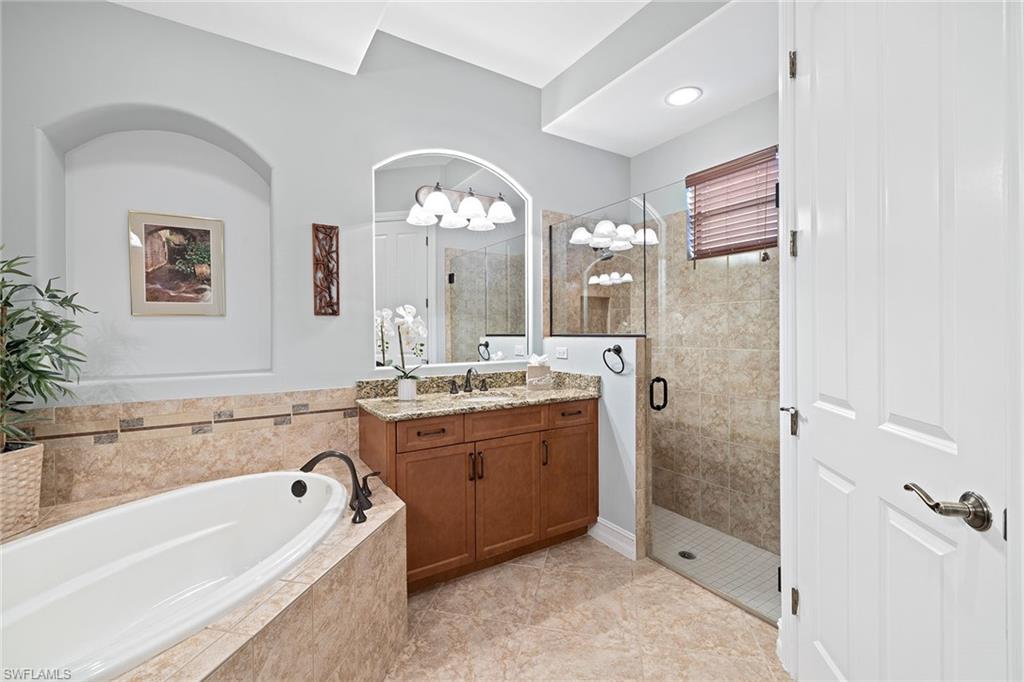 6513 Caldecott Drive Naples, FL 34113 - Photo 27 of 33 a bathroom with a tub a sink shower and mirror