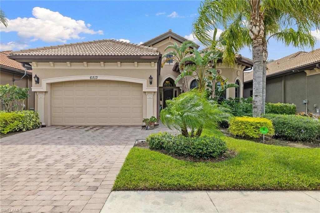 6513 Caldecott Drive Naples, FL 34113 - Photo 5 of 33 a front view of a house with a garden