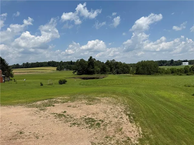 a view of a fountain in front of a house with a big yard