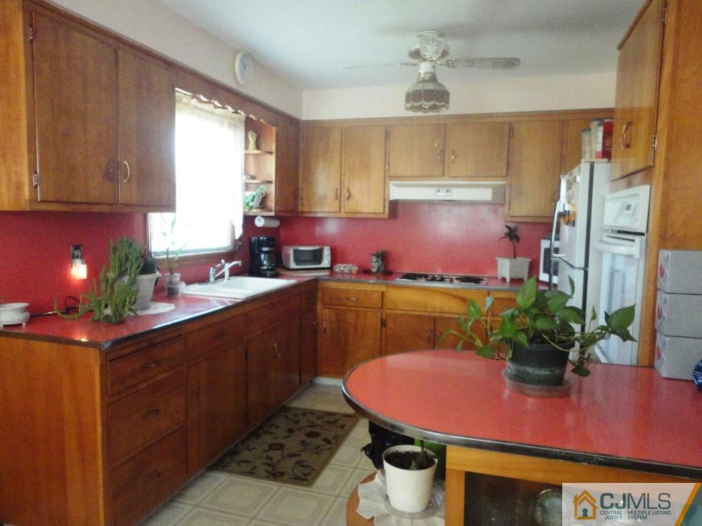 33 Enfield Road Colonia, NJ 07067 - Photo 3 of 9 a kitchen with stainless steel appliances granite countertop a sink dishwasher and cabinets with wooden floor