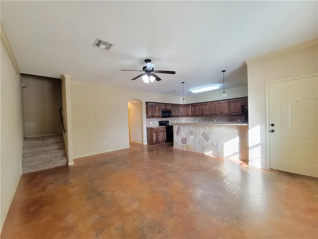 a view of a livingroom with a ceiling fan and kitchen view