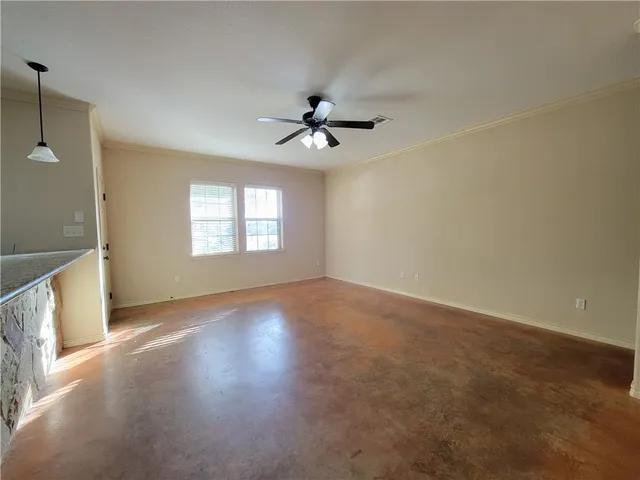 an empty room with windows and ceiling fan