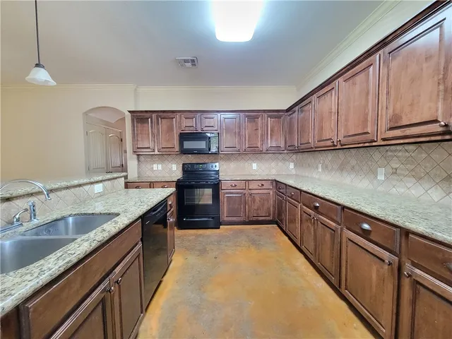 a kitchen with stainless steel appliances granite countertop a sink stove and cabinets