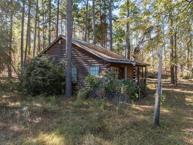 a backyard of a house with wooden fence and large trees