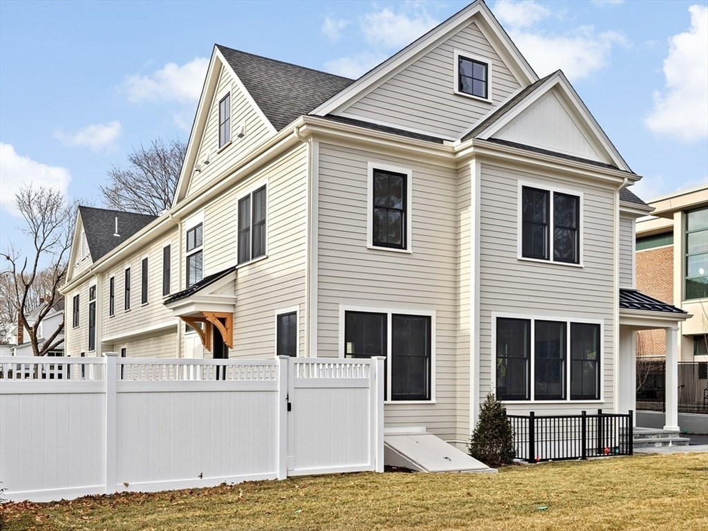 32 Kingsbury Street, Unit A Wellesley, MA 02482 - Photo 14 of 14 a view of a white house with large windows next to a yard