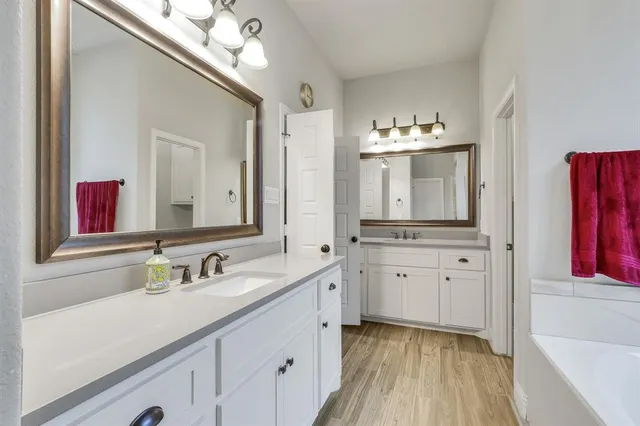 a spacious bathroom with a double vanity sink and a mirror