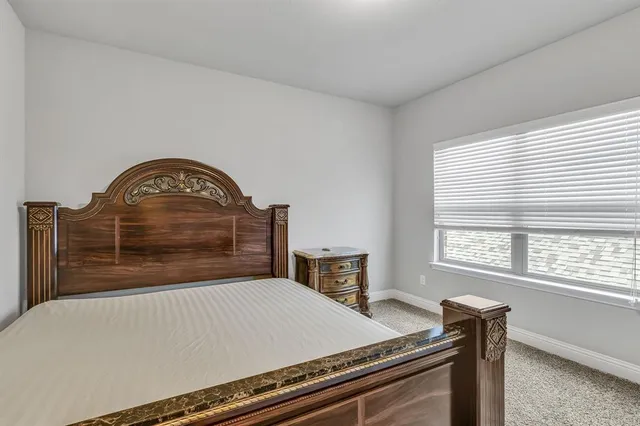 a bed sitting in a bedroom next to a window