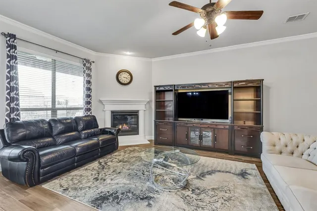 a living room with furniture a flat screen tv and a fireplace