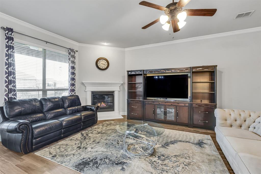 1306 Elizabeth Street Anna, TX 75409 - Photo 23 of 36 a living room with furniture a flat screen tv and a fireplace
