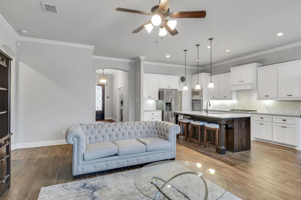 1306 Elizabeth Street Anna, TX 75409 - Photo 6 of 36 a large living room with stainless steel appliances kitchen island granite countertop furniture and a fireplace