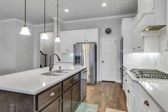 a kitchen with a sink a counter space and stainless steel appliances