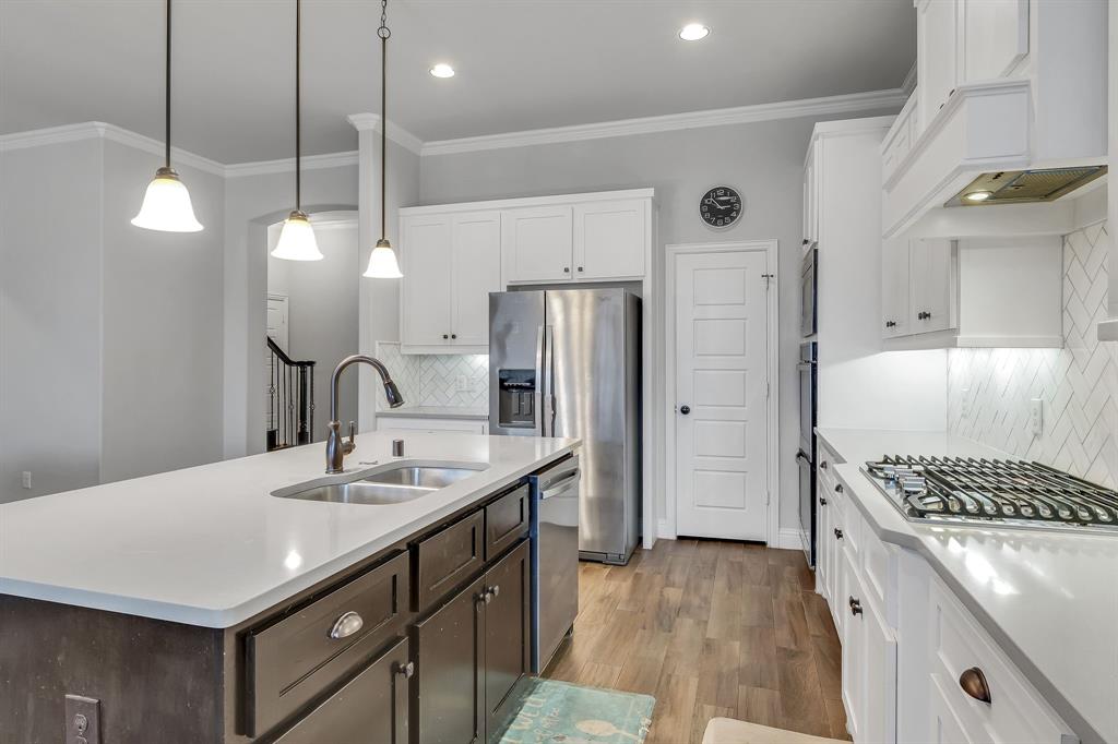 1306 Elizabeth Street Anna, TX 75409 - Photo 9 of 36 a kitchen with a sink a counter space and stainless steel appliances