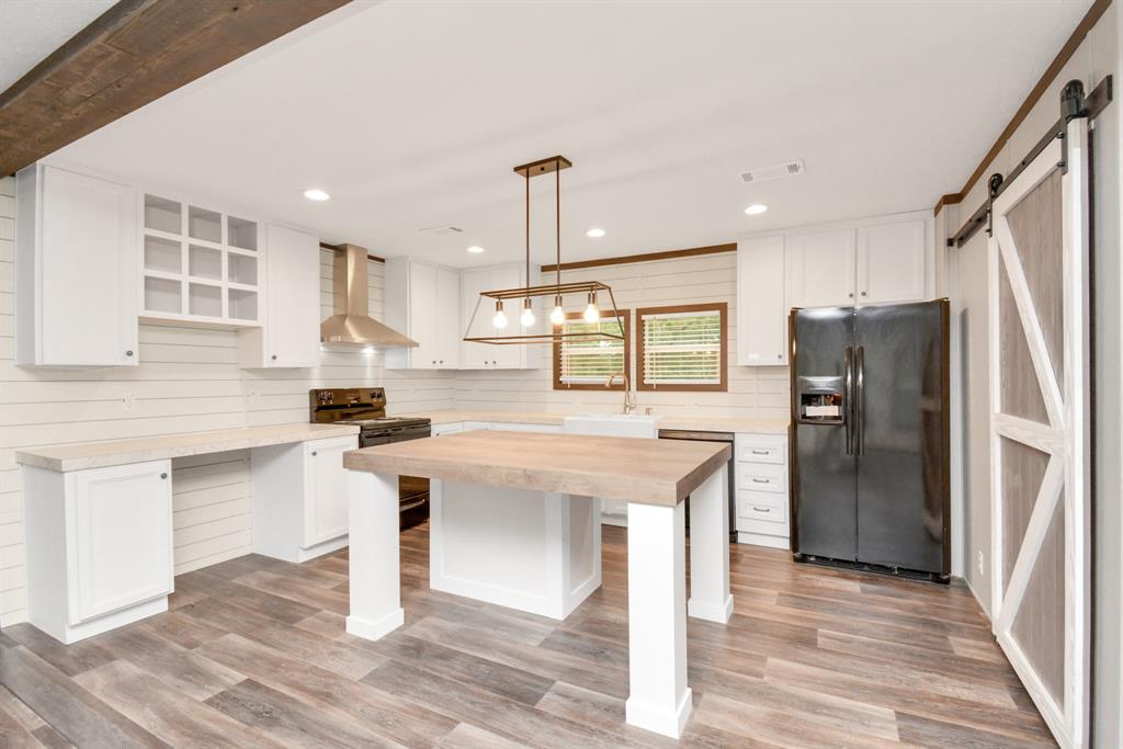 a kitchen with stainless steel appliances kitchen island hardwood floor sink and stove