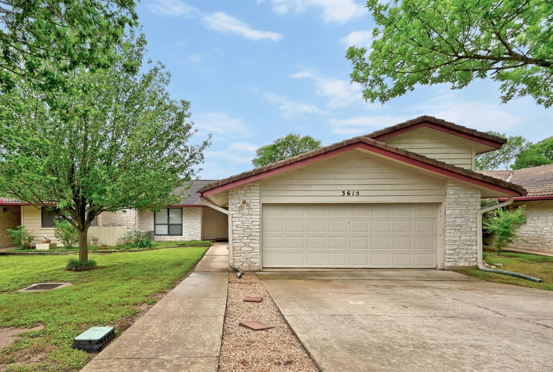 a small white house with a white roof and table and chairs under an umbrella