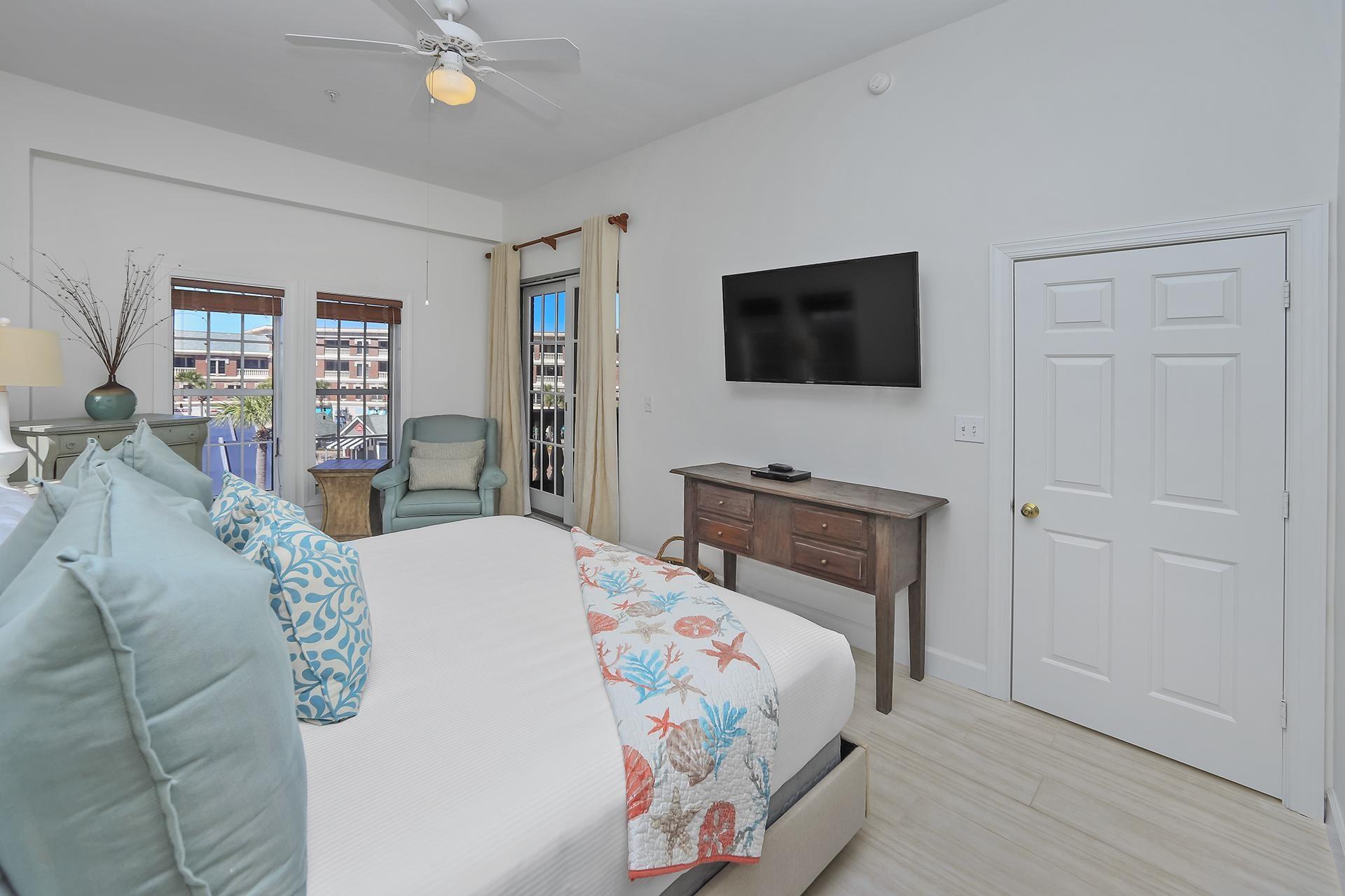 10343 East County 30-a Hwy Inlet Beach, Unit 305 Inlet Beach, FL 32461 - Photo 14 of 19 a bedroom with a bed a flat screen tv and a chandelier