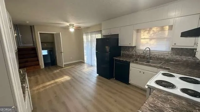 a kitchen with granite countertop a refrigerator stove and sink