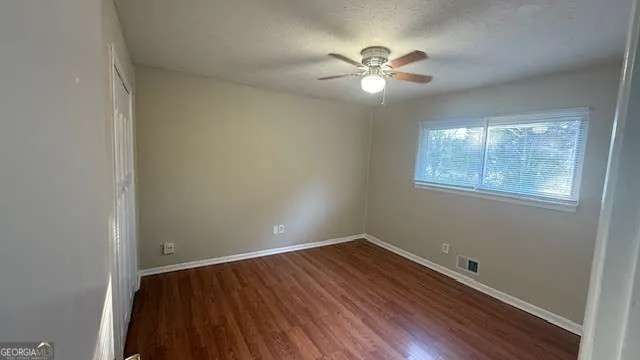 a view of a room with wooden floor and windows