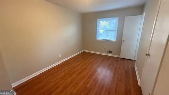 a view of a room with wooden floor and window