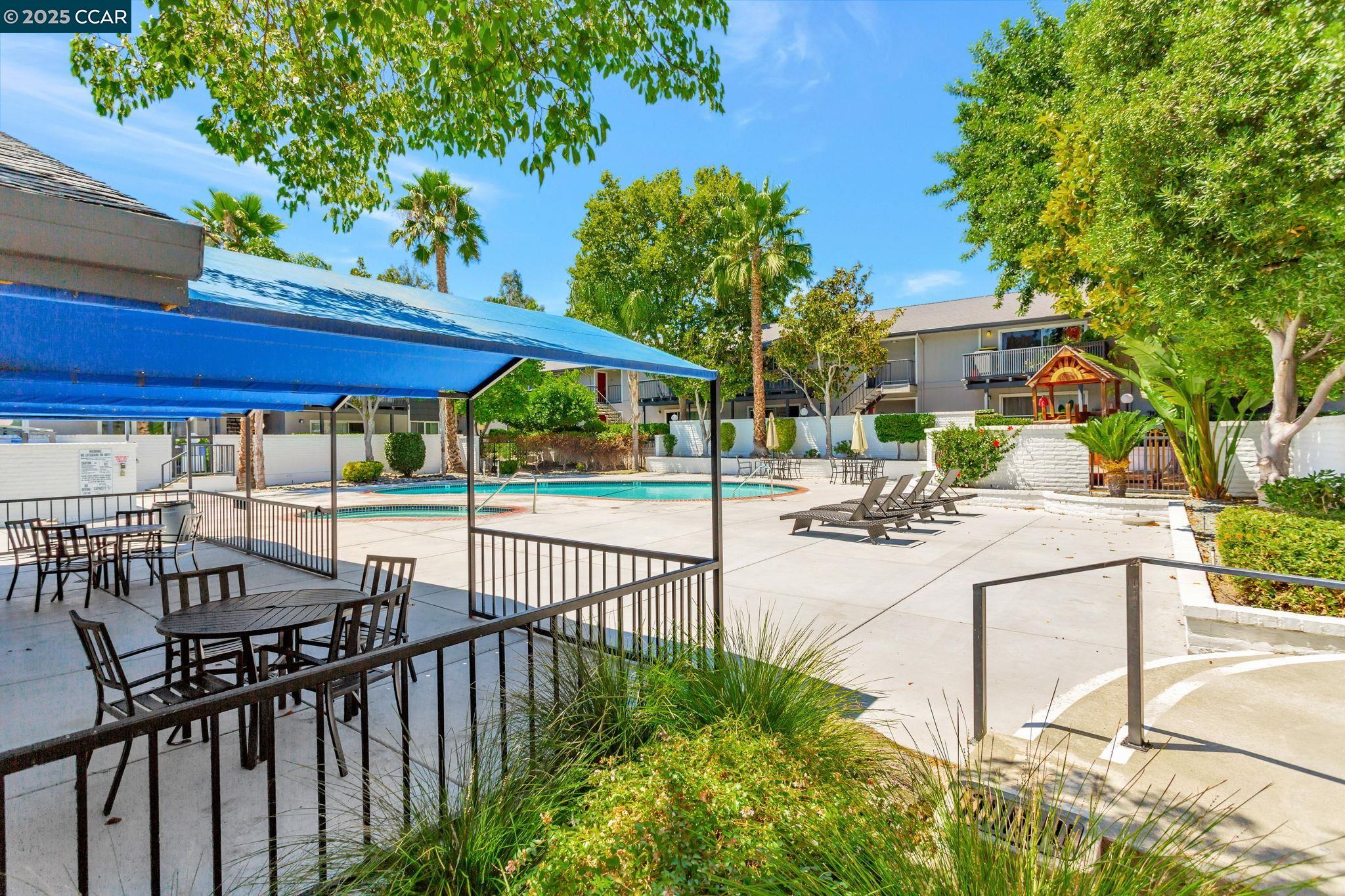9085 Alcosta Boulevard, Unit 340 San Ramon, CA 94583 - Photo 22 of 25 a view of a patio with a table and chairs under an umbrella with wooden fence