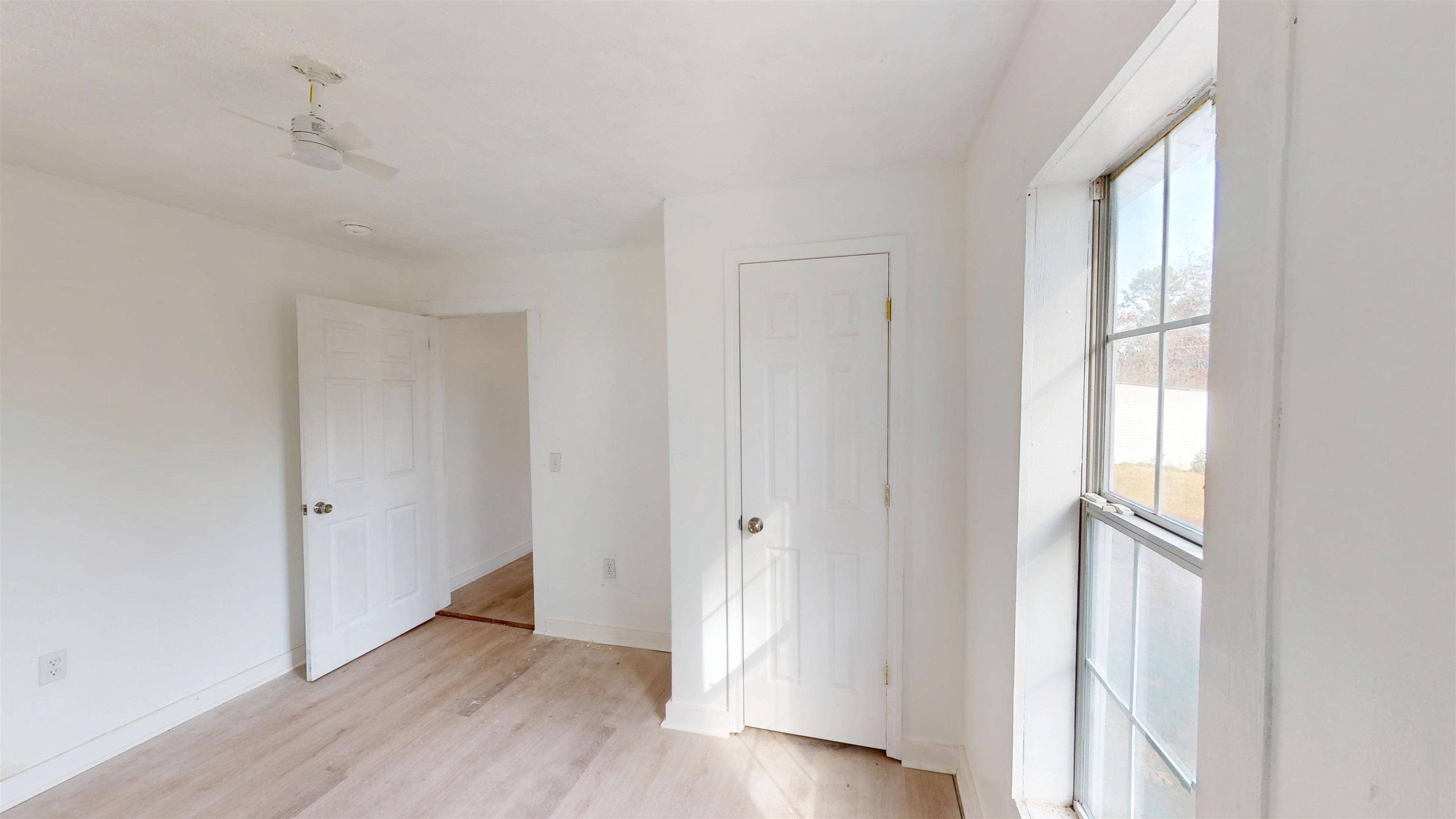 1907 Elmer Cox Road Bethel Springs, TN 38315 - Photo 9 of 17 an empty room with wooden floor and windows