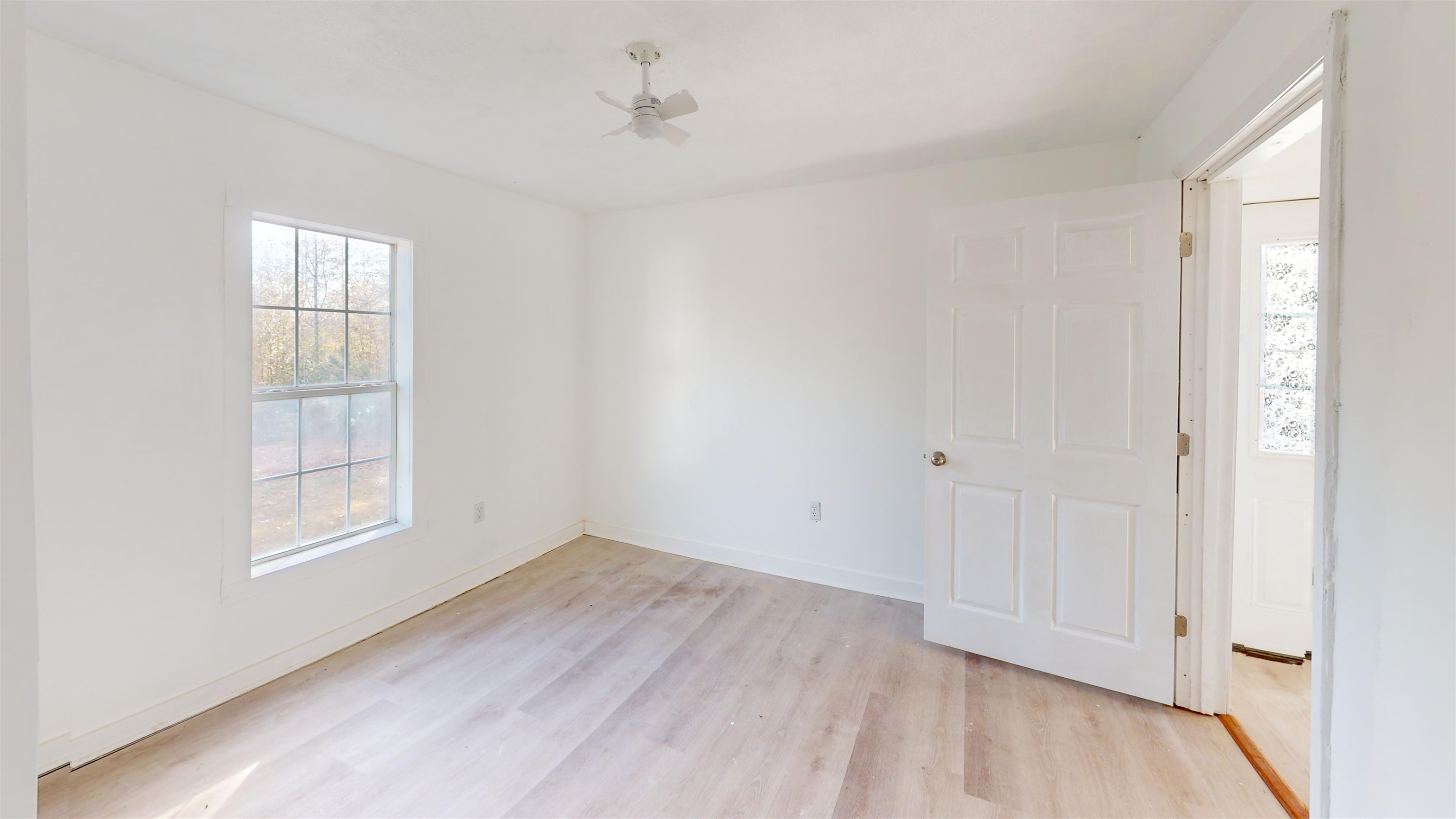 1907 Elmer Cox Road Bethel Springs, TN 38315 - Photo 10 of 17 a view of empty room with wooden floor and fan