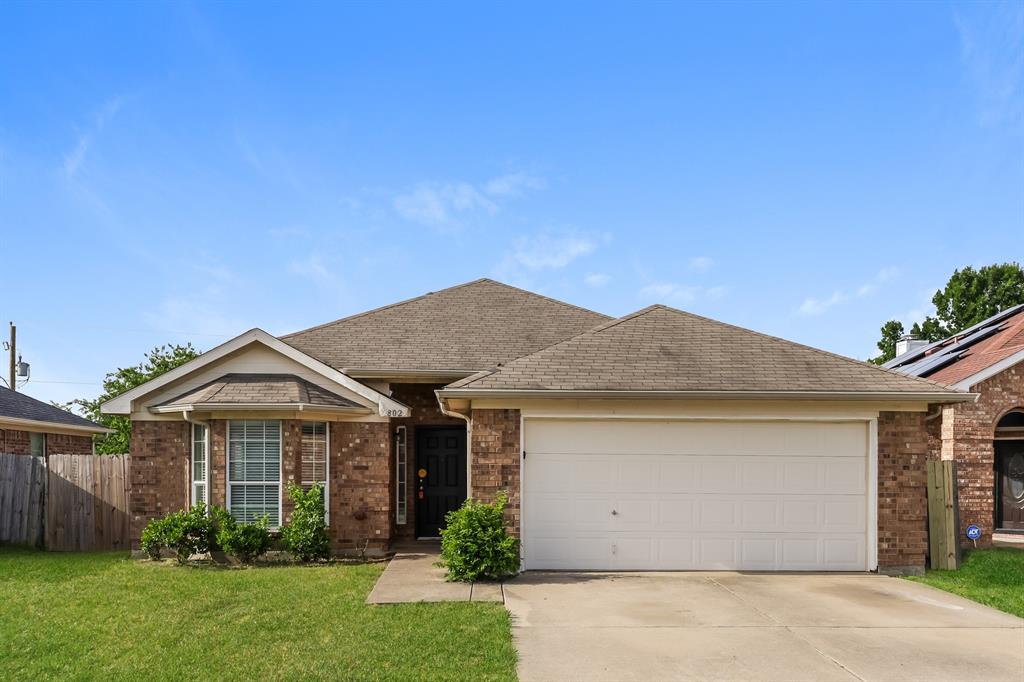 a front view of a house with a garden and yard