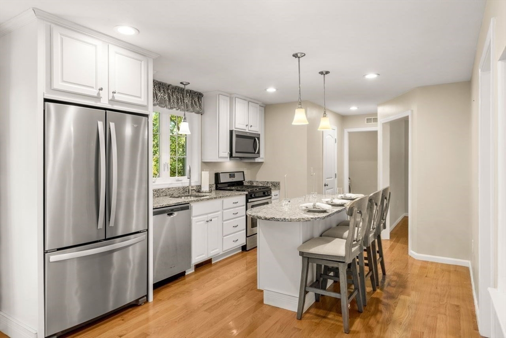 79 Bridle Road Billerica, MA 01821 - Photo 11 of 42 a kitchen with refrigerator a sink and chairs