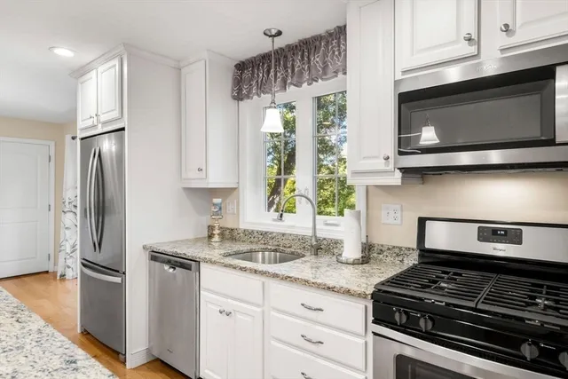a kitchen with stainless steel appliances granite countertop a stove a microwave and a refrigerator