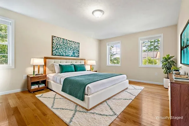 a bedroom with a large bed a rug and a window