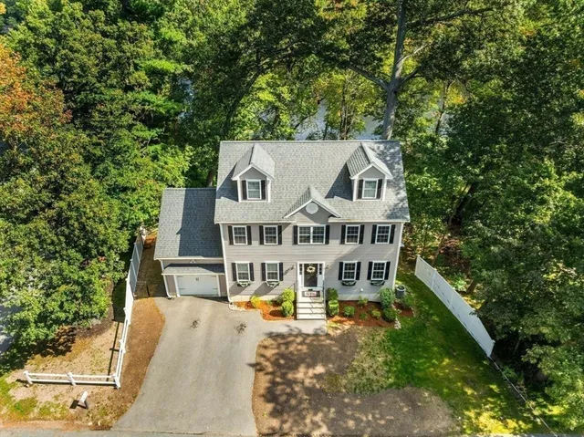 an aerial view of a house with a large trees