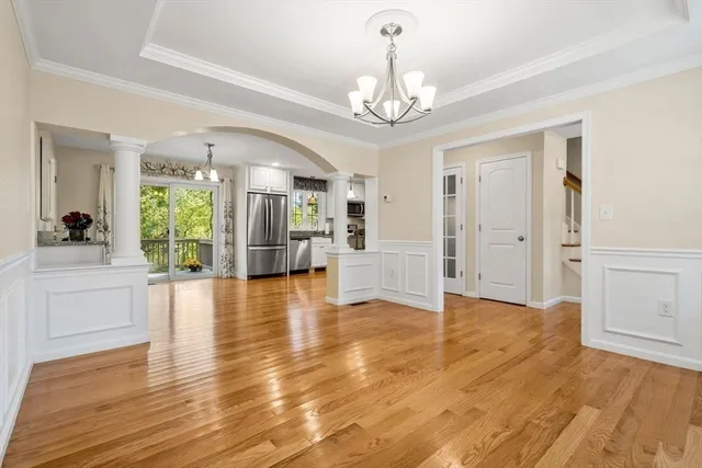 a view of a hallway with wooden floor windows and a chandelier