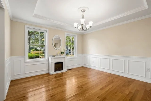 an empty room with wooden floor fireplace and windows