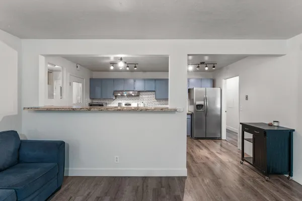 a view of kitchen with refrigerator and wooden floor