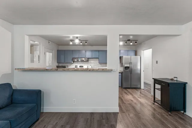 a view of kitchen with refrigerator and wooden floor
