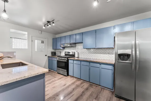 a kitchen with granite countertop stainless steel appliances cabinets a sink and a center island