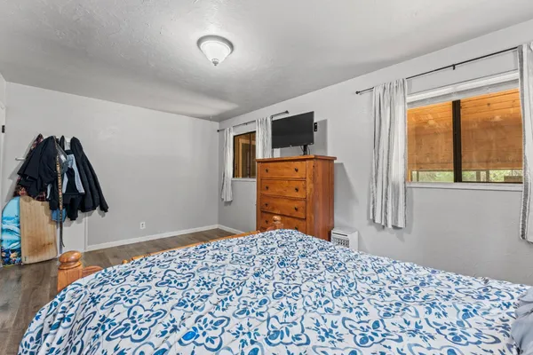a bedroom with a bed and a flat tv screen next to a window