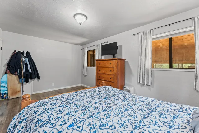 a bedroom with a bed and a flat tv screen next to a window