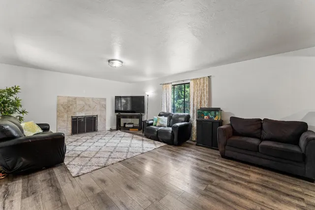 a living room with furniture a fireplace a flat screen tv and potted plant