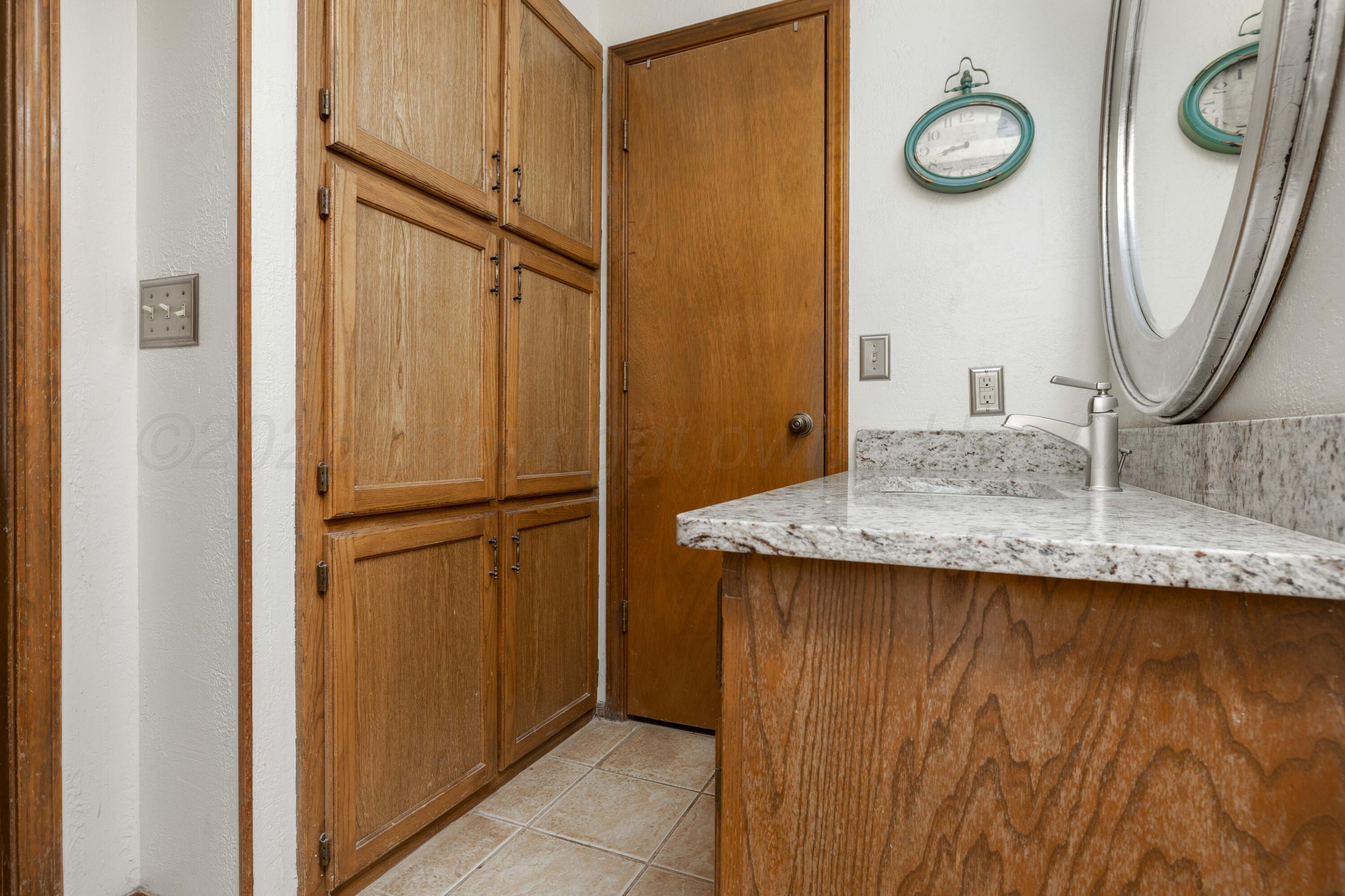 6801 Rochelle Lane Amarillo, TX 79109 - Photo 24 of 40 a bathroom with a granite countertop sink and a mirror