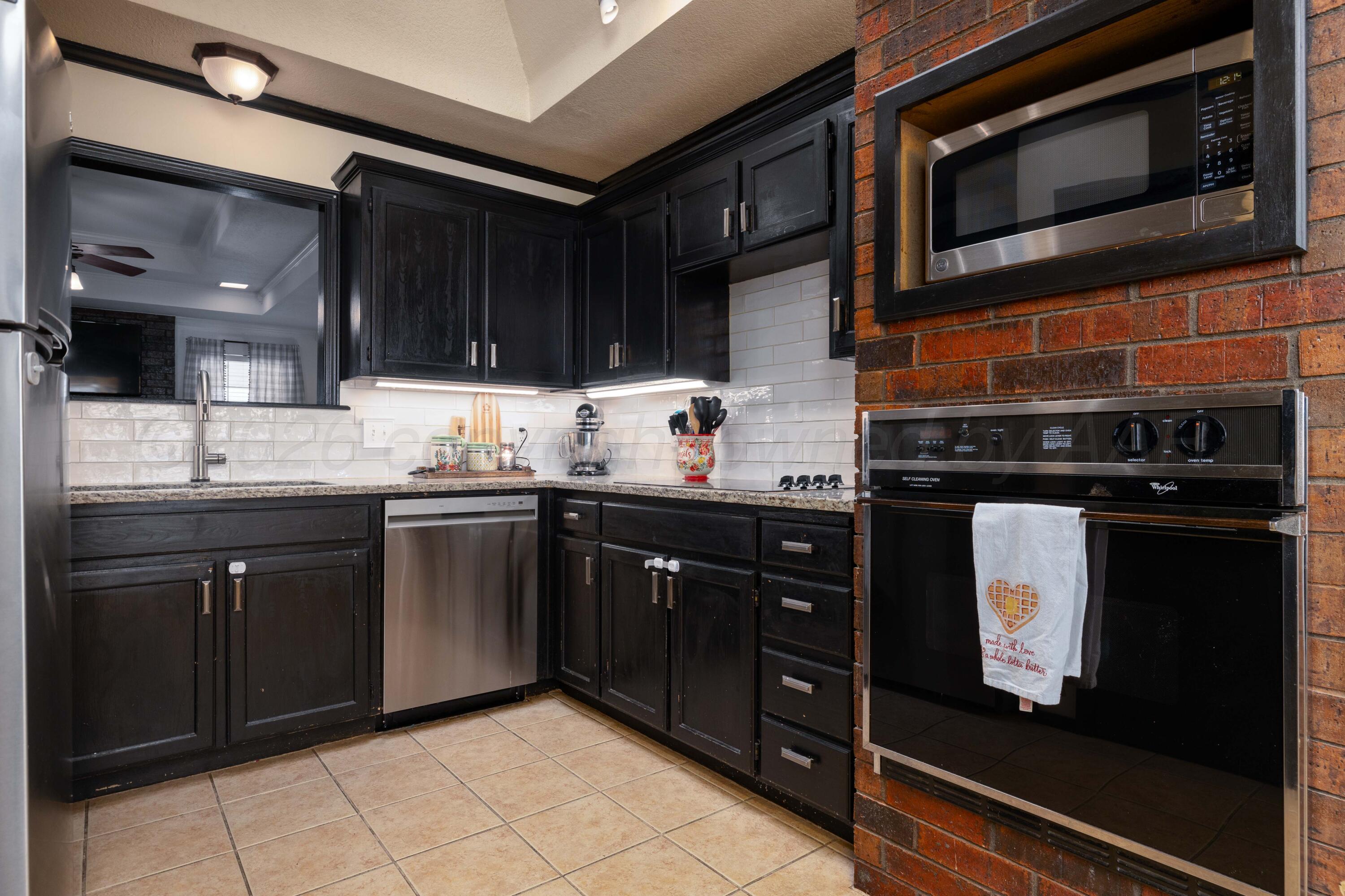 6801 Rochelle Lane Amarillo, TX 79109 - Photo 8 of 40 a kitchen with stainless steel appliances granite countertop a stove microwave and sink