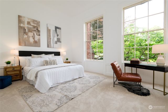 a bedroom with a bed and a large window