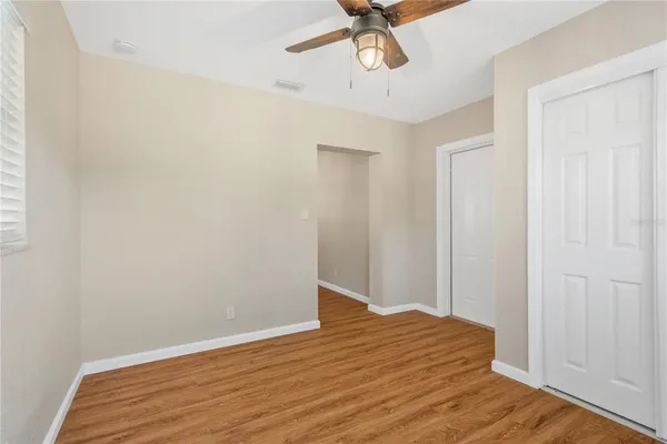 a view of a room with wooden floor and ceiling fan