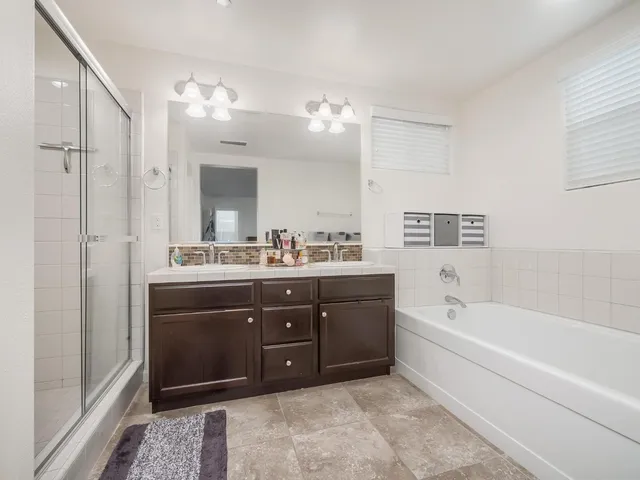 a spacious bathroom with a tub sink and mirror