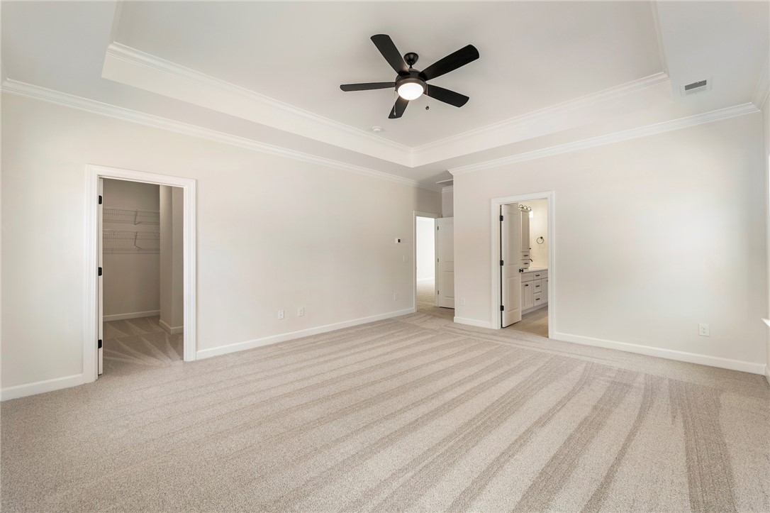 114 Lakeside Drive Anderson, SC 29621 - Photo 18 of 37 This expansive primary bedroom offers a private retreat with elegant crown molding and soft carpeting.